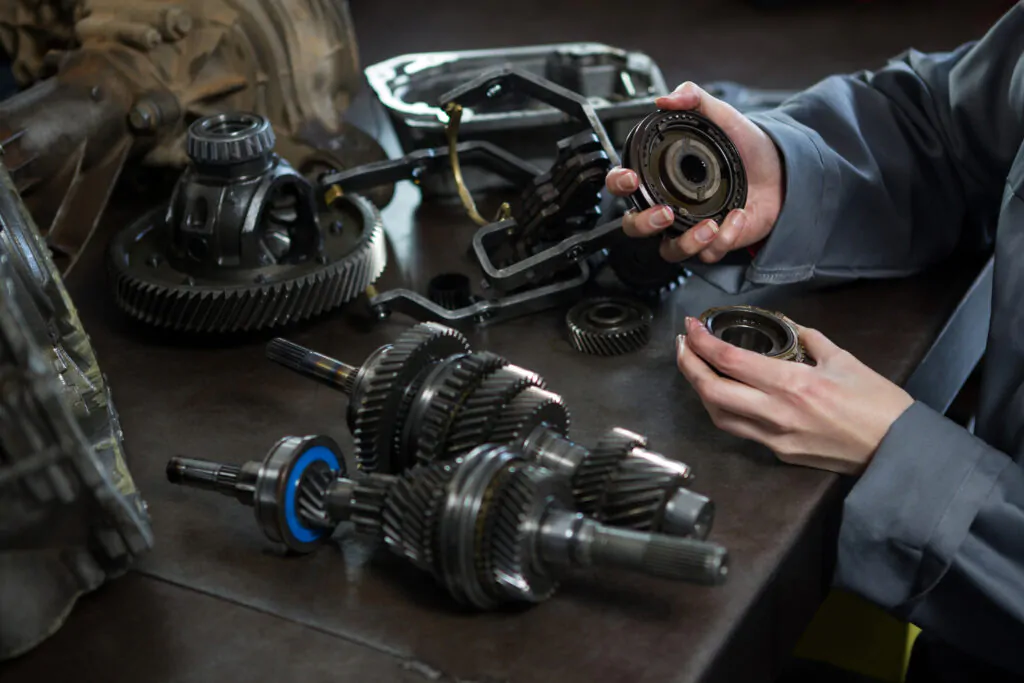 female mechanic holding spare parts car